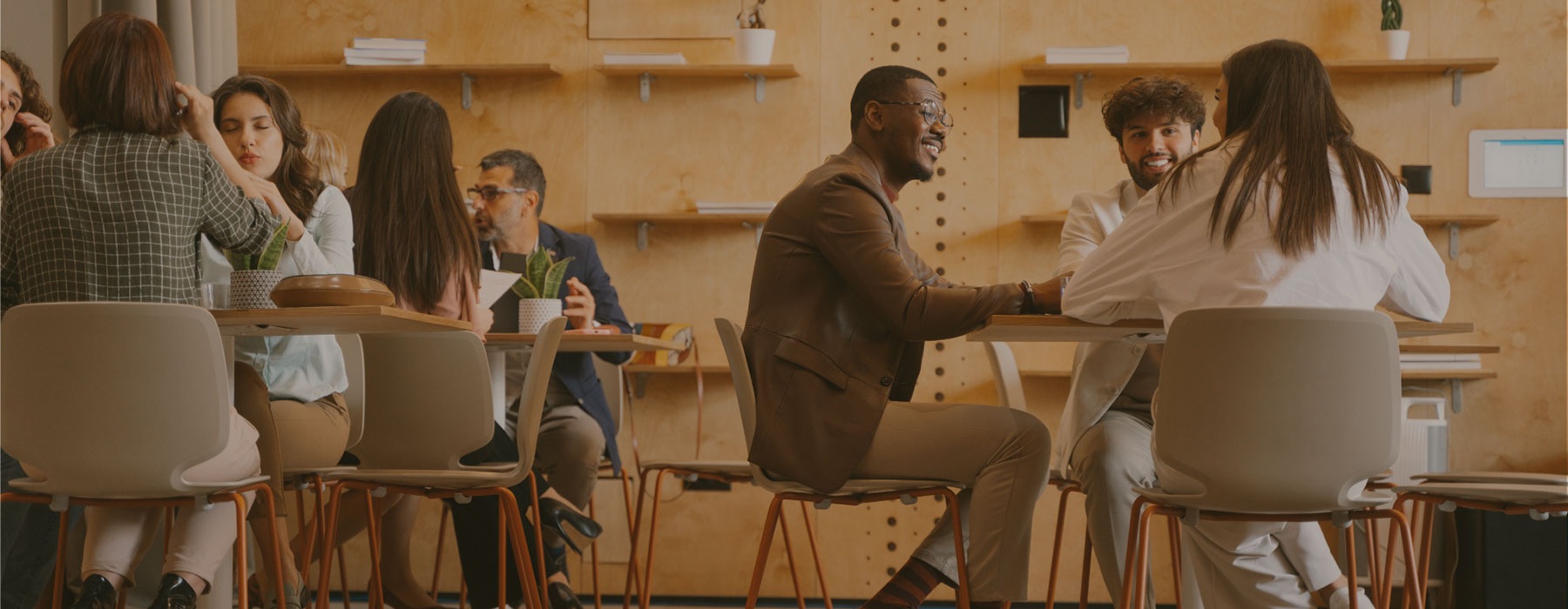 people sitting at tables in large room